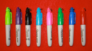 Pictured are mini Sharpies.  Full-sized versions can also be used.  They range in price from approximately $1 to $3 each. 